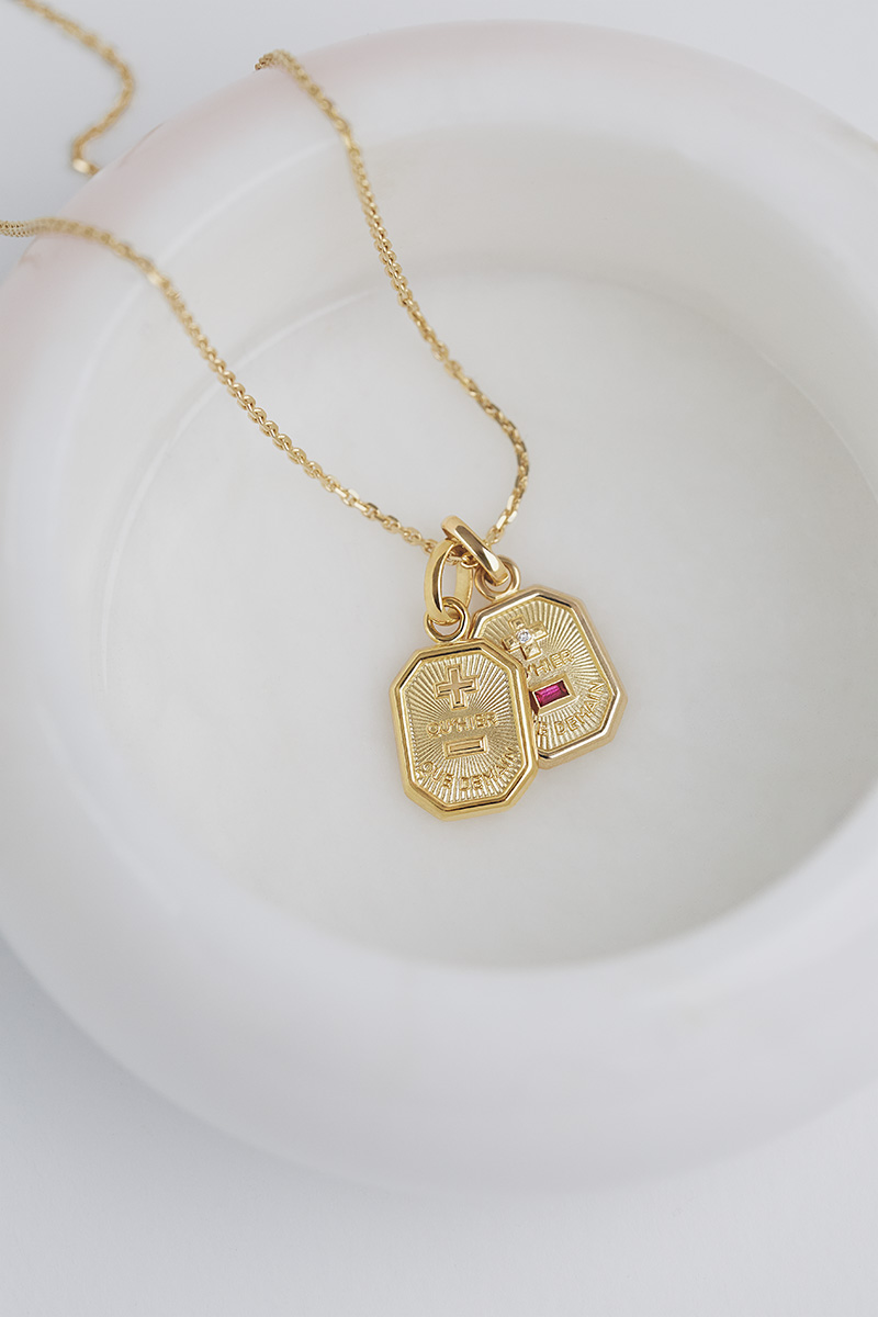 Collier doré avec pendentifs photographié sur fond blanc