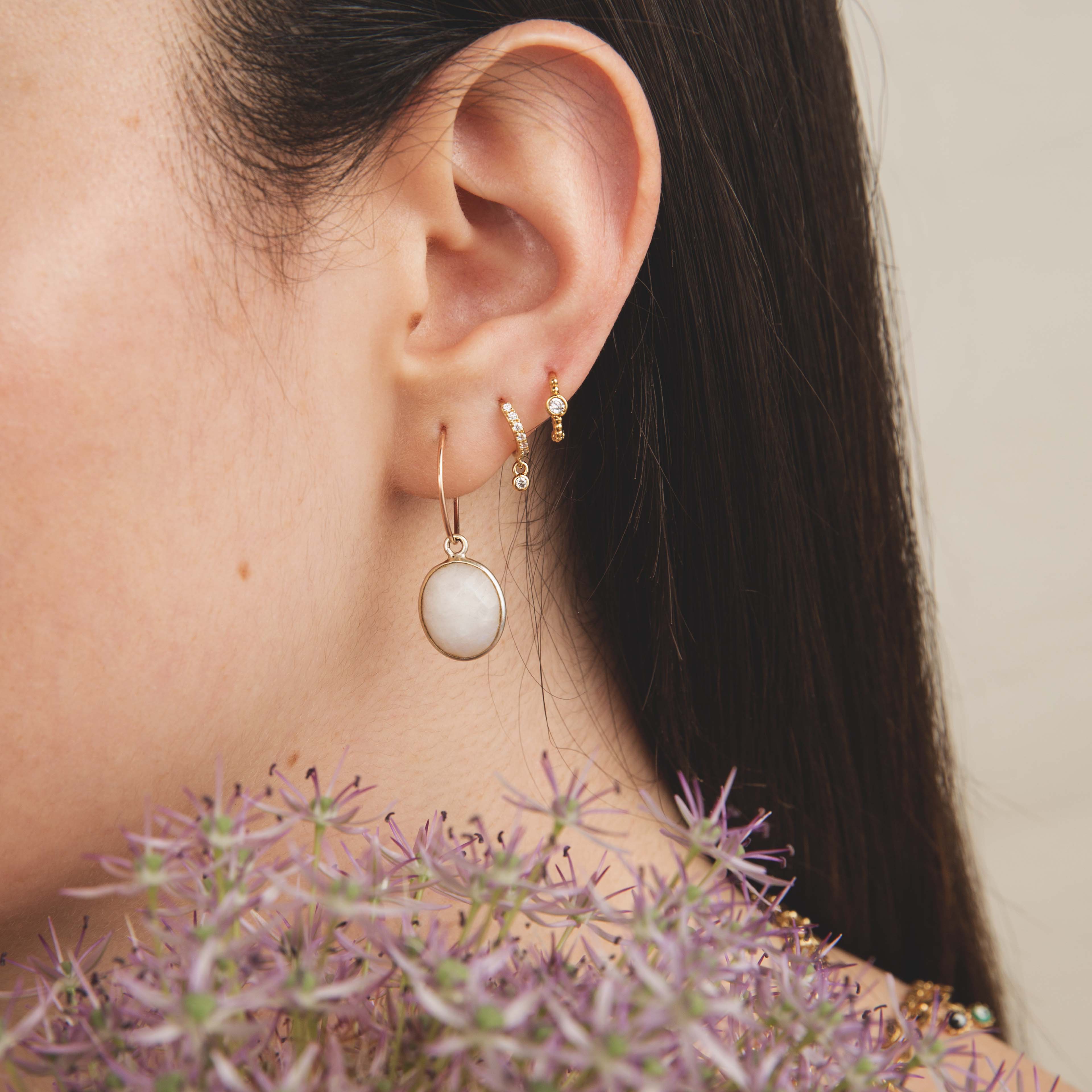 Boucles d’oreilles pendantes dorées avec pierre blanche