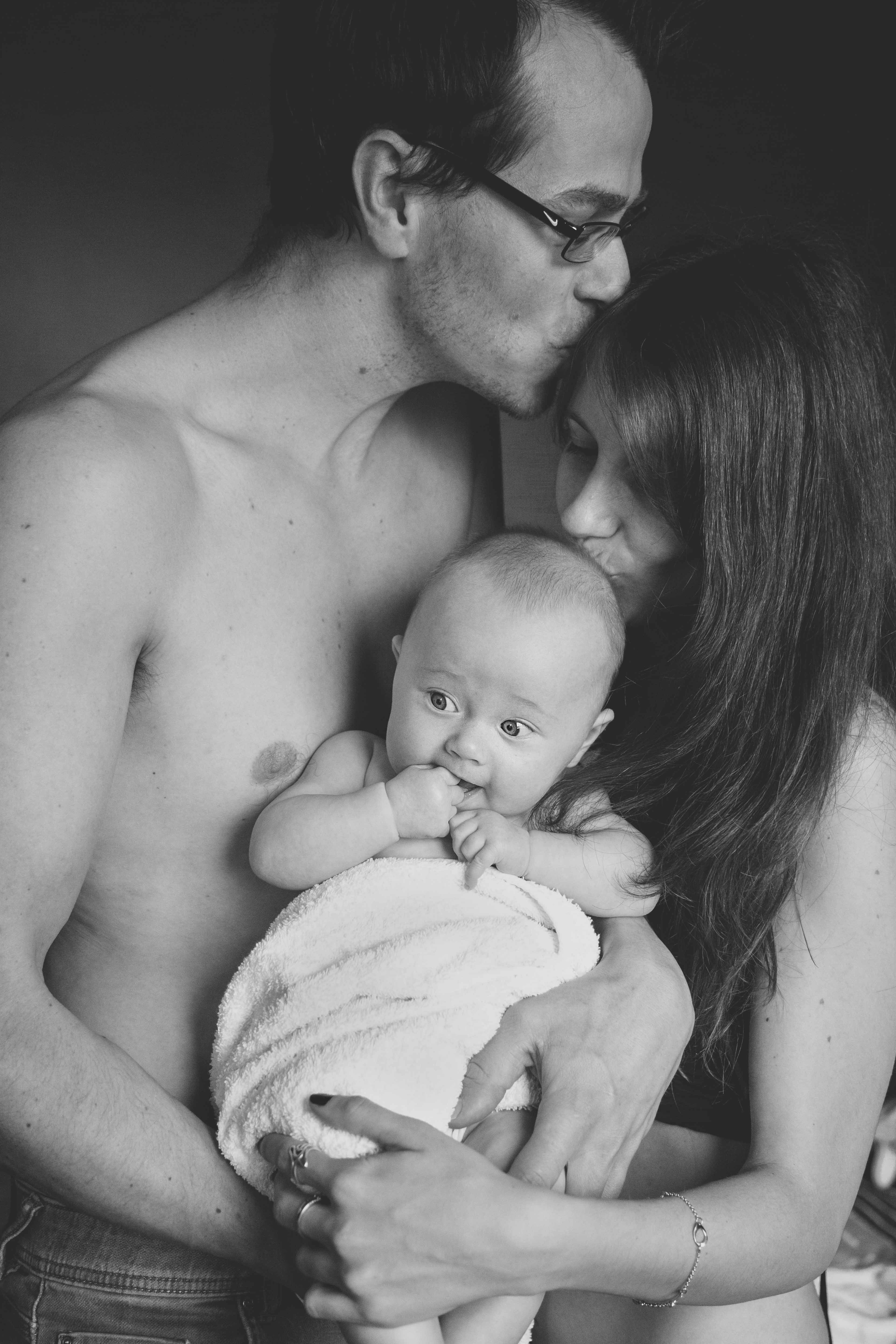 Jeune couple embrassant leur bébé emmailloté